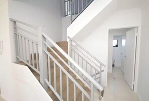 A staircase with white railings leading to a second floor. - Discover Your Dream Oasis in Mandurah! (Mandurah)