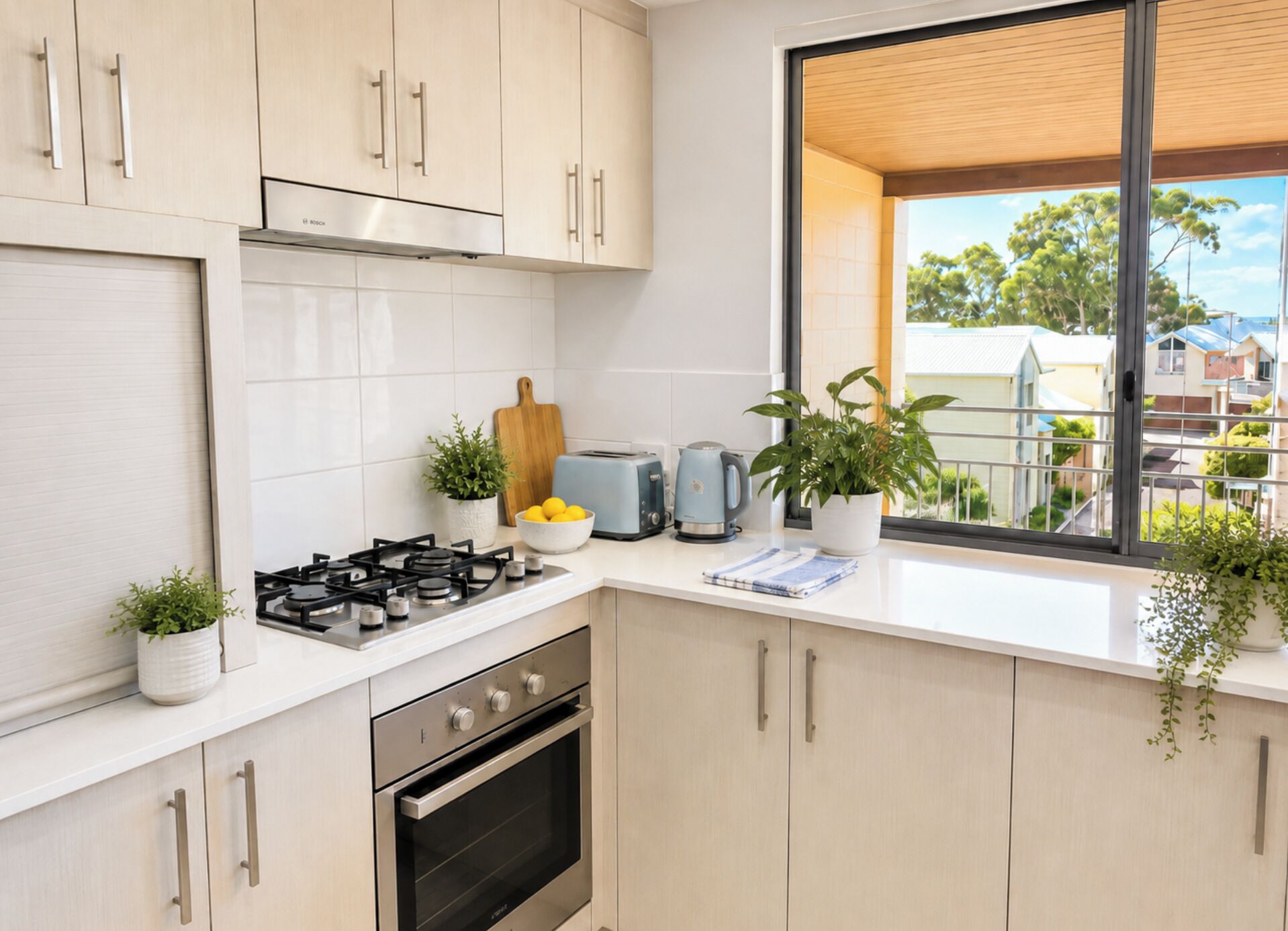 Eine moderne Küche mit Gasherd, Backofen und einem Fenster mit Blick auf eine Wohngegend.