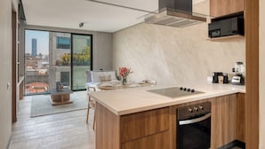 A modern kitchen with a large island, built-in oven, and a microwave. - Brand New 1 BR Condo in Roma Norte - Rooftop (Mexico City)