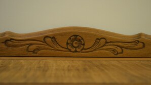 A close-up of a wooden surface with carved floral and leaf patterns. - Individual room in the Heart of the town (El Calafate)