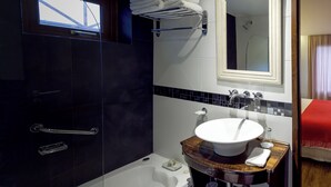 A modern bathroom with a glass-enclosed shower, a white sink with a wooden vanity, and a mirror above the sink. - Standard Double Room (Queen Bed) (El Calafate)