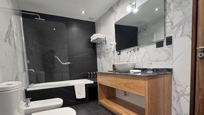 Un baño moderno con inodoro, bidé y bañera.