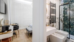 A modern bathroom with a large mirror, white sink, and dual shower stalls.