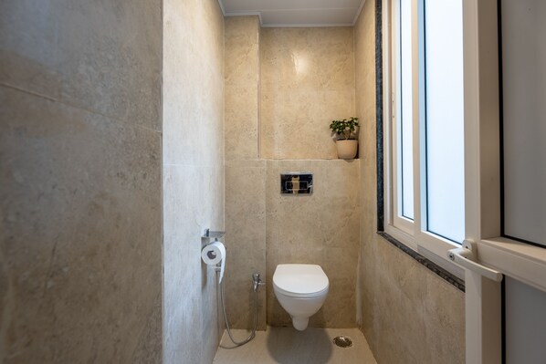 A bathroom with a toilet, a shower, and a window. - Moustache Hostel Gangtok (Gangtok)