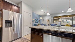 A modern kitchen with stainless steel appliances, a dishwasher, and a granite countertop. - NEW Paradise Splash Villa! (Kissimmee)