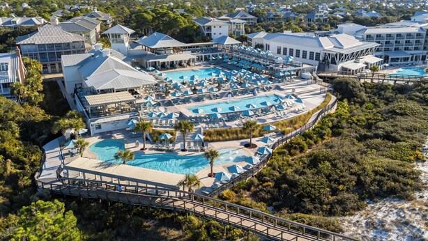 Un resort con varias piscinas, zonas de descanso y un puente que conecta diferentes áreas.