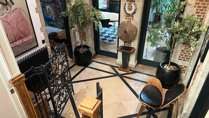 Un intérieur moderne avec un motif géométrique sur le sol, des meubles noirs et en bois, et des plantes en pot.