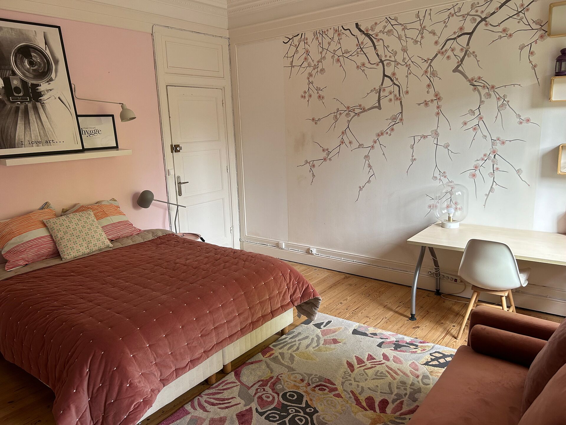 A bedroom with a bed, a desk, and a chair.