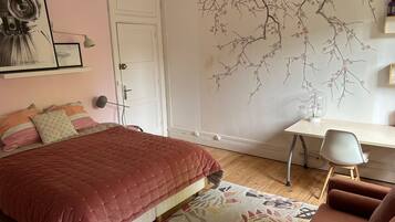 A bedroom with a bed, a desk, and a chair.