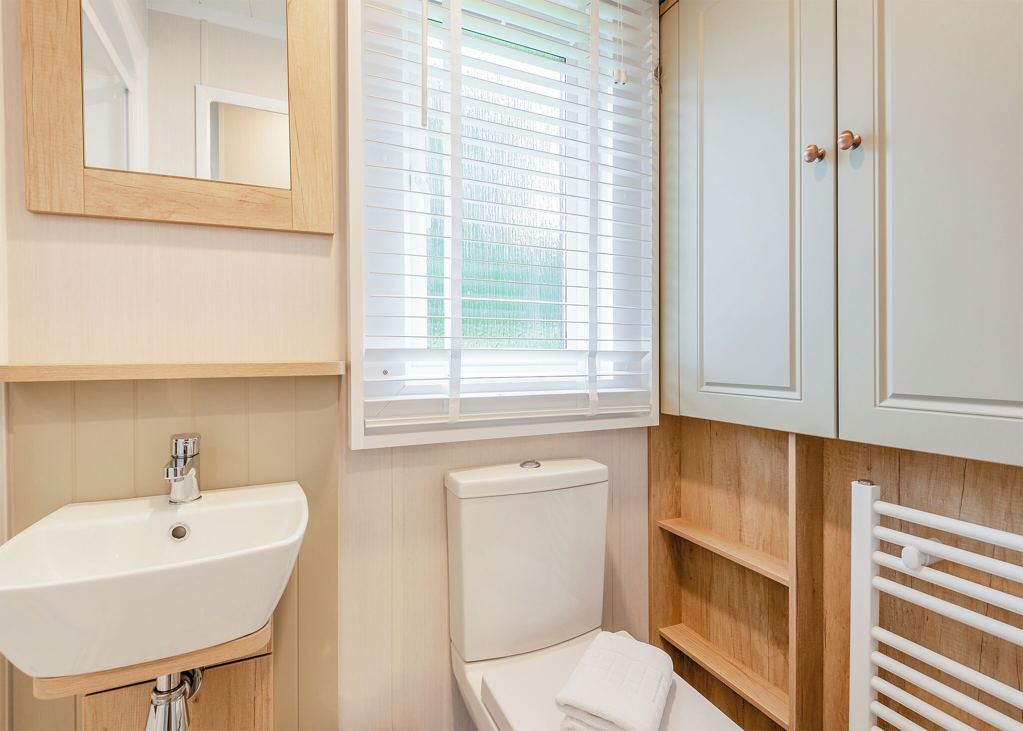 A bathroom with a sink, toilet, and a mirror.