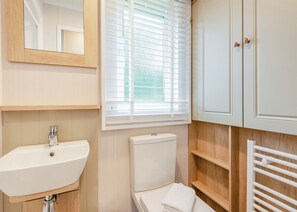 A bathroom with a sink, toilet, and a mirror. - 2 bedroom accommodation in Bala, (Bala,)
