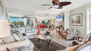 Ein geräumiges Wohnzimmer mit Deckenventilator, Essbereich und Blick ins Freie.