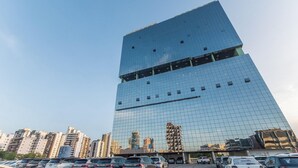 A modern high-rise building with a reflective glass facade and a unique geometric design. - Your Complete Stay in a Building With Pool and Gym, 290m From Shopping da Bahia - Ibfs (Salvador)
