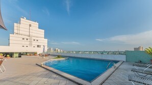 A rooftop swimming pool with a clear blue sky, a modern building with a white facade, and a few lounge chairs. - Your Complete Stay in a Building With Pool and Gym, 290m From Shopping da Bahia - Ibfs (Salvador)