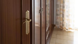 Een kamer met een grote houten garderobe, een decoratief gordijn en betegelde vloer.