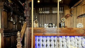 A bar area with a wooden counter, a blue-lit display, and various bar tools and bottles. - Pirates Inn Themed 3 bedroom cottage, with bar & pool table (Tregaron)