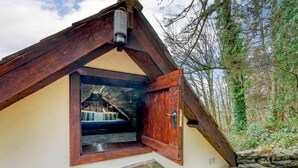 A rustic cabin with a stone staircase leading to a wooden door. - Pirates Inn Themed 3 bedroom cottage, with bar & pool table (Tregaron)