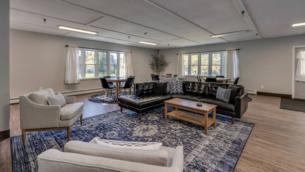 Un salon spacieux comprenant un grand canapé, une table basse et un coin repas avec des chaises et une table.