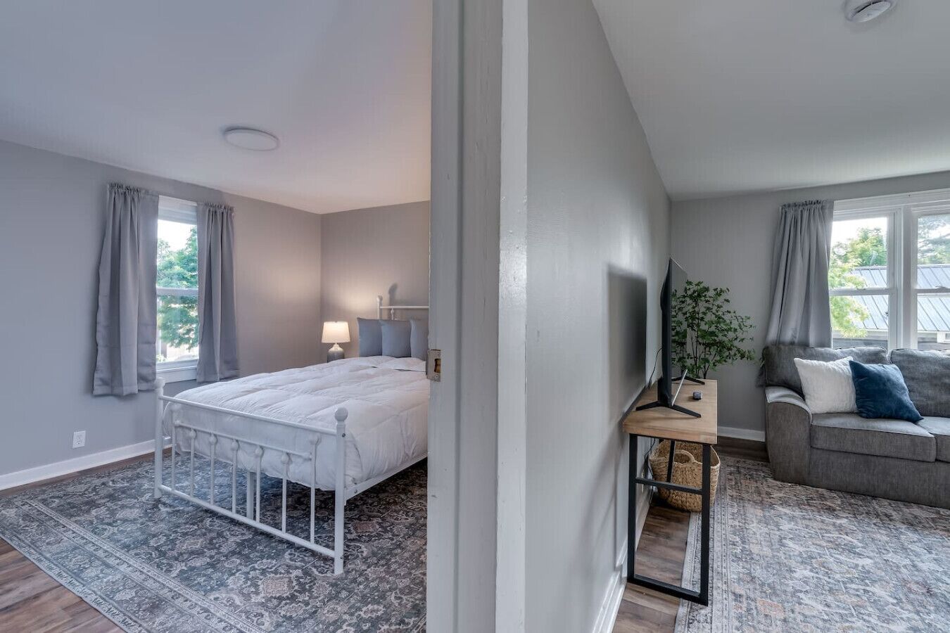Une chambre à coucher avec un lit, une table de chevet, une télévision et un canapé.