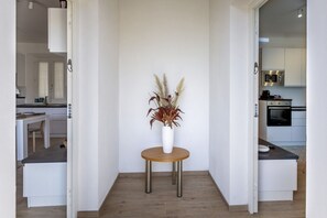 Une cuisine moderne avec des meubles blancs, un four à micro-ondes et une cuisinière.
