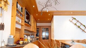 Una cocina acogedora con armarios de madera, una mesa de comedor y una silla con forma de corazón.
