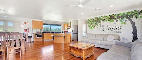Una sala de estar moderna con una mesa de centro de madera, un sofá y un comedor con sillas de madera.