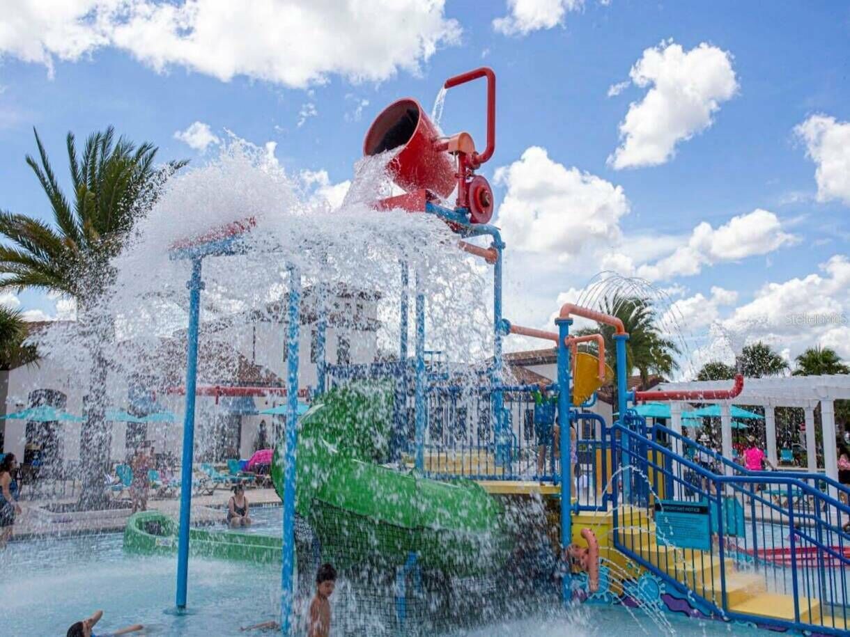 A water park with a water slide, a pool, and a play structure.