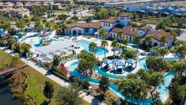 Vue aérienne d’un complexe hôtelier doté de plusieurs piscines, de palmiers et d’immeubles d’habitation.