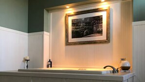 Een keuken met een inbouwkookeiland, een lijst met een foto boven de spoelbak en een kleine tafel met een kaars.