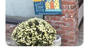A sign for a loft tour site with a date and time, and a potted plant with yellow flowers. - Enchanting Historic Spa Loft. 3rd story private deck/jetted tub/Heart of Madison (Madison)