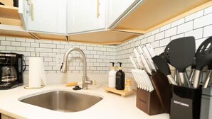 A kitchen with white cabinets, a stainless steel sink, a coffee maker, and a knife block. - 7 bdrm 7 bth 3 kitchens NW DC w/parking & balcony (Washington)