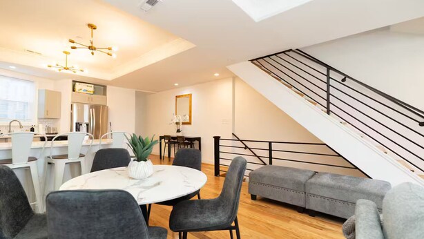 A modern living space with a dining area, kitchen, and staircase. - 7 bdrm 7 bth 3 kitchens NW DC w/parking & balcony (Washington)