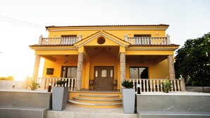 Una casa a due piani con un balcone, un ingresso e un piccolo portico.