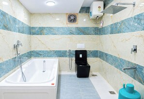 A bathroom with a bathtub, a toilet, a shower, and a hand dryer. - Priya Residency Pondicherry (Vanur)
