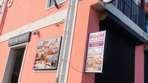 A pink building with a sign for Priya Residency and a 'Rooms Available' sign. - Priya Residency Pondicherry (Vanur)