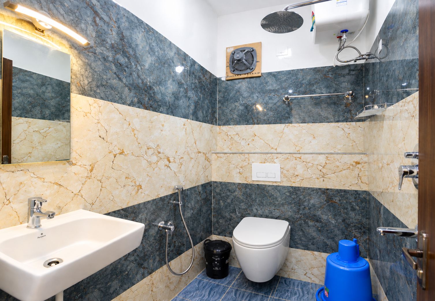 A bathroom with a sink, toilet, shower, and a mirror.