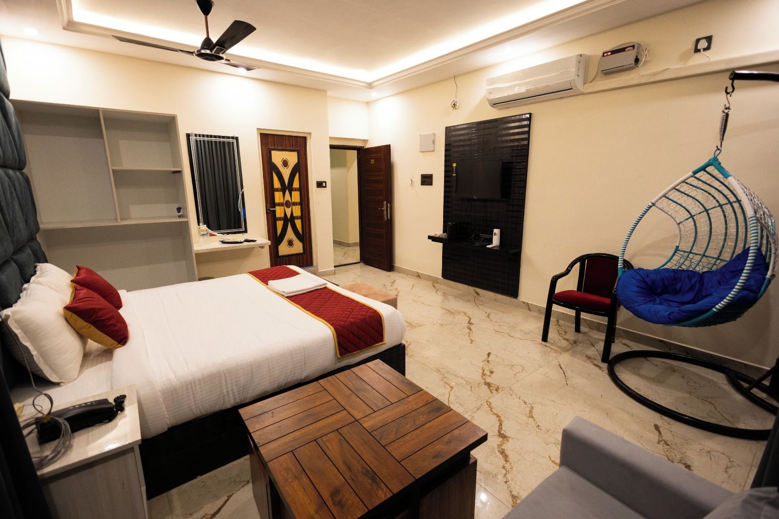 Una habitación de hotel con cama, escritorio, sillón colgante y armario.