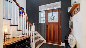 A staircase with white balusters leading to a dark wooden door with a frosted glass panel. - Hôtel à la maison - Entre Mont et rivière (Orford)