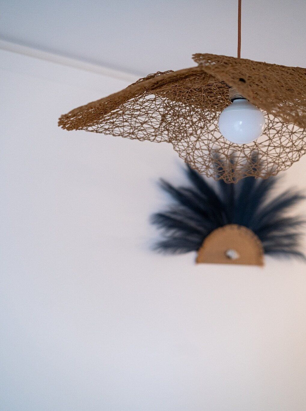 A hanging light fixture with a spherical bulb and a net-like structure.