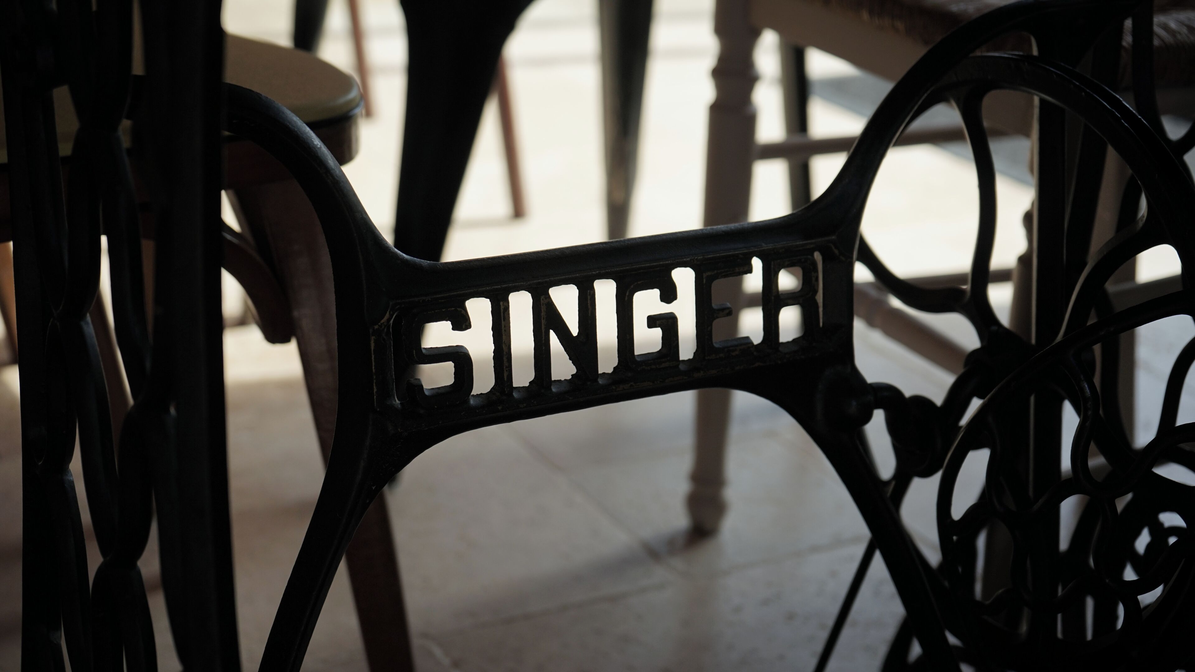 Un primo piano di una sedia in metallo con schienale, sulla quale è incisa la scritta "SINGH".