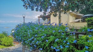 A stone pathway leading to a building with a view of the sea. - Villa Rosamaria (Maratea)