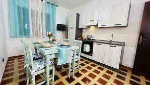 A compact kitchen with white cabinets, a black stove, and a tiled floor. - Cozy Apartment in Center of Tropea, 5 min from Station, free parking (Tropea)