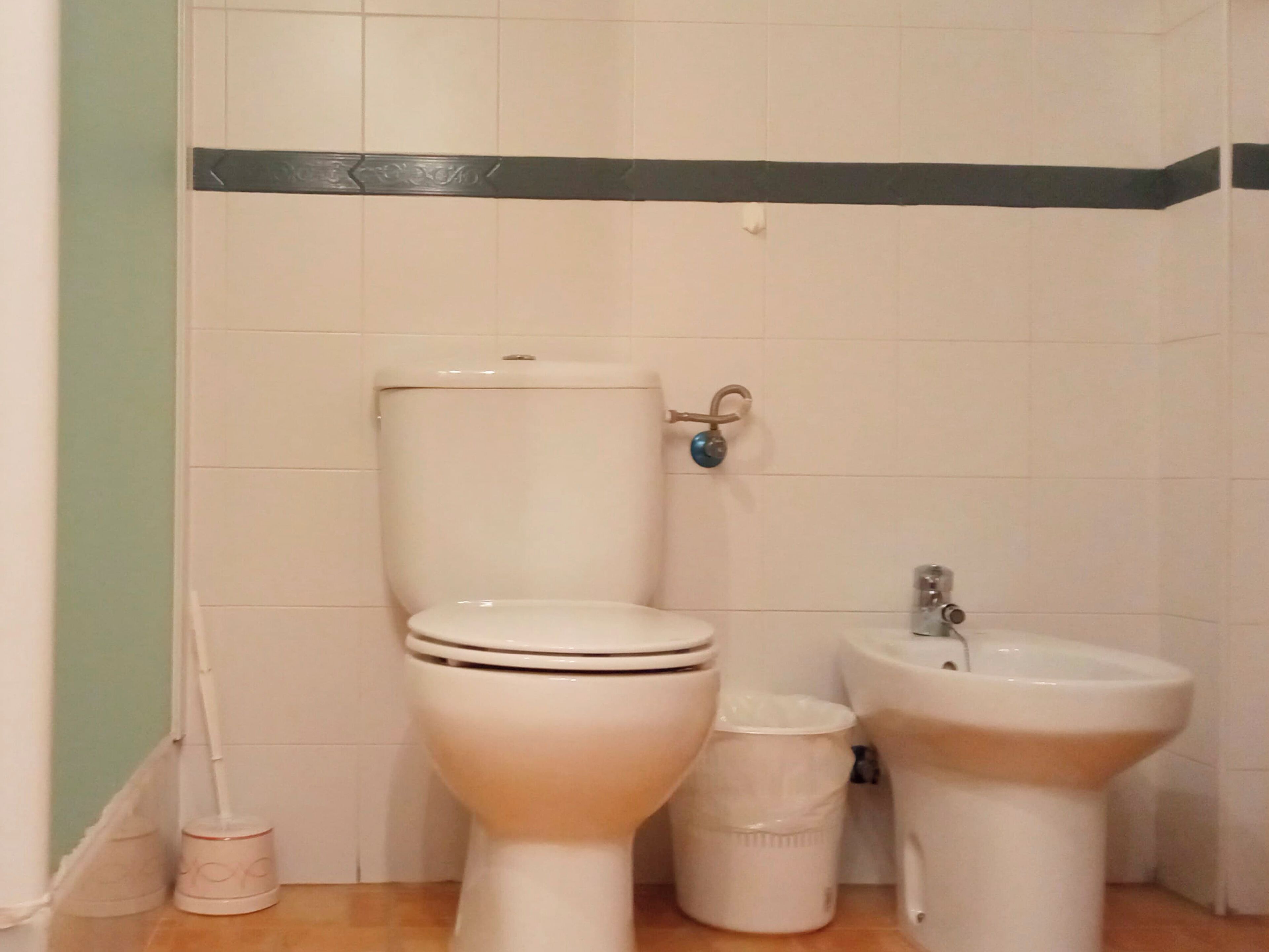 Un baño con inodoro, bidé y lavamanos.
