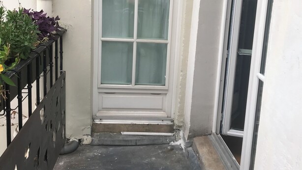 A narrow entrance with a white-framed window and a black metal gate. - Very charming 1 bed room in heart of paris with balcony (Paris)