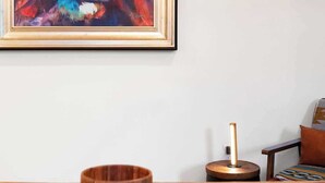 A dining area with a wooden table, a bowl, and a framed painting of a lion's face. - Summit Haus  Cozy Getaway in the Poconos (Pocono Summit)