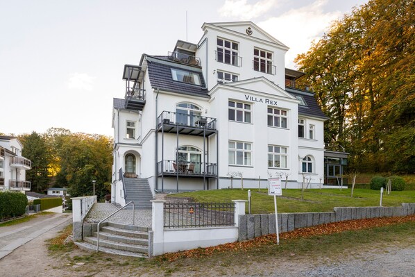 Een meerlaags gebouw met een opvallende ingang, een balkon en een bord dat aangeeft dat het een restaurant is.