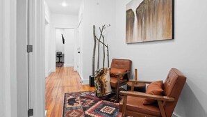 A modern interior with a wooden floor, a patterned rug, leather chairs, and a painting on the wall. - Lakeside Serenity Retreat Near Kalahari Resort (Pocono Summit)