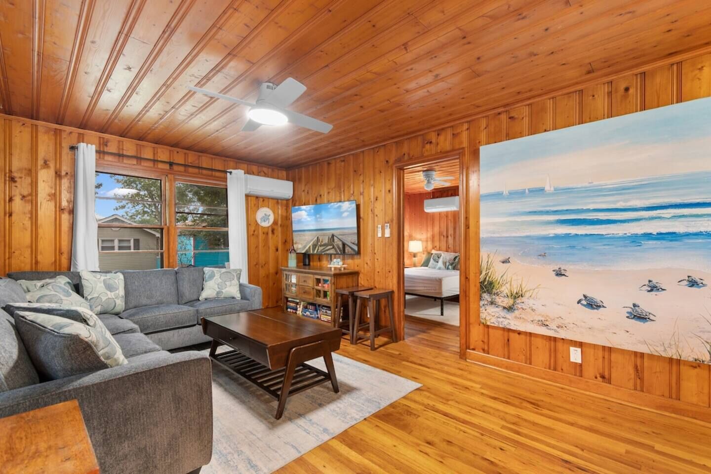 A cozy cabin interior with a living room, a dining area, and a bedroom.