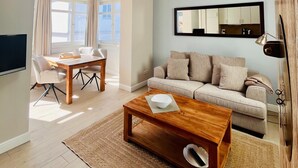 A spacious living area with a skylight, a dining table, a sofa, and a coffee table. - Apartment "Halbinsel Mönchgut" with Balcony and Wi-Fi (Binz)