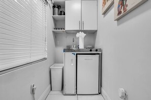 A compact kitchen with a refrigerator, a sink, and a small countertop. - Tropical Haven | Cozy 1 BR Caribbean Getaway (Miami)